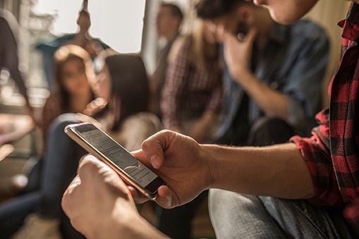 Young adult using a phone while taking a break from class